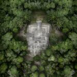 Discover the ancient Chacchoben pyramid nestled in lush greenery from a high aerial perspective.