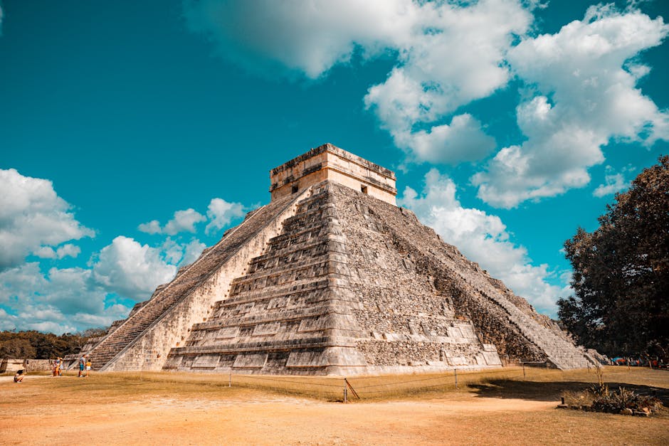 The iconic El Castillo pyramid at Chichen Itza, Mexico, captured on a sunny day with a vibrant blue sky.